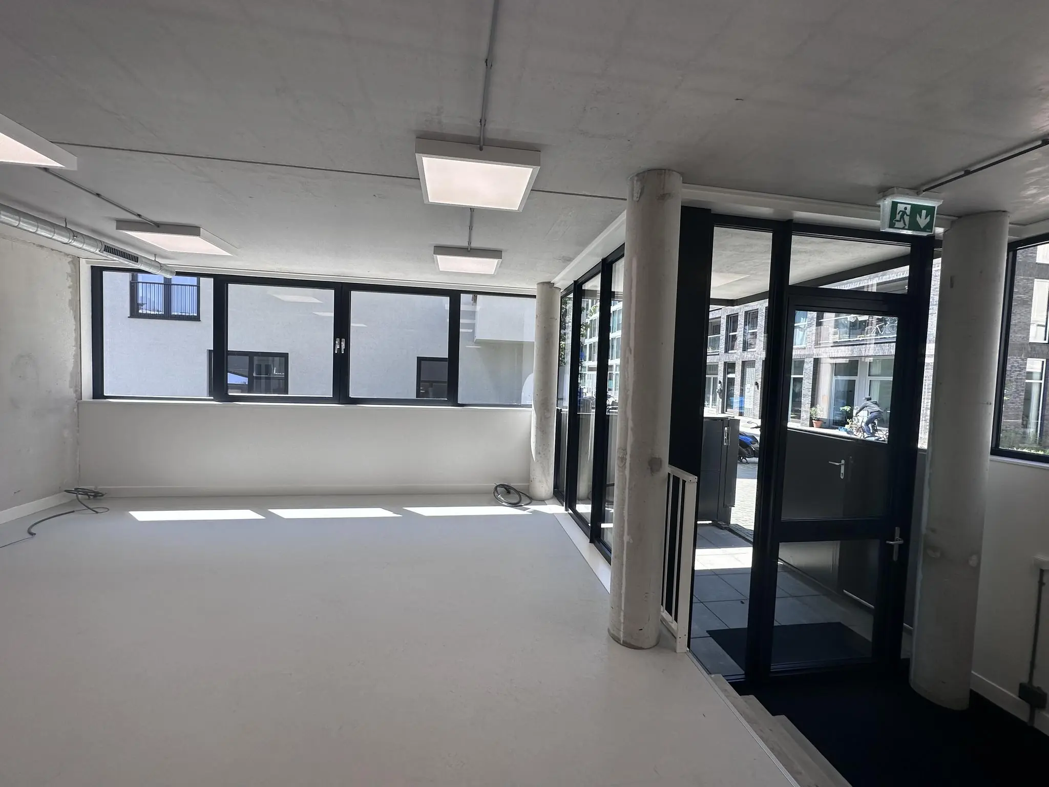 Lichte, lege kantoorruimte met grote ramen en een entree aan de Willem Parelstraat.