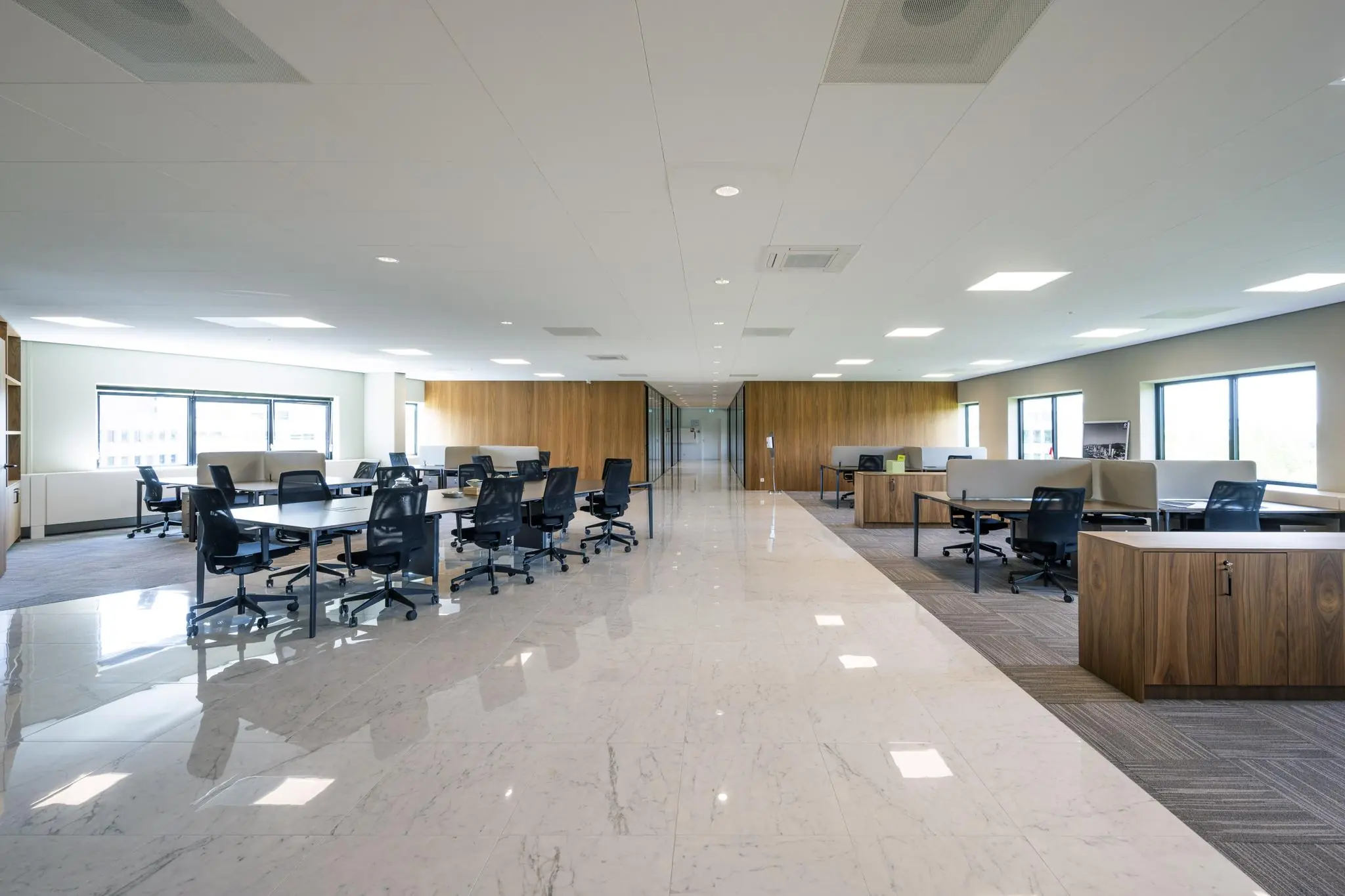 Ruim en modern kantoorinterieur aan de Wegalaan met open werkplekken en houten afwerkingen.