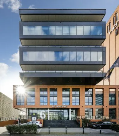 Modern kantoorgebouw De Winthont aan de Winthontlaan met opvallende glazen verdiepingen en rode bakstenen gevel.