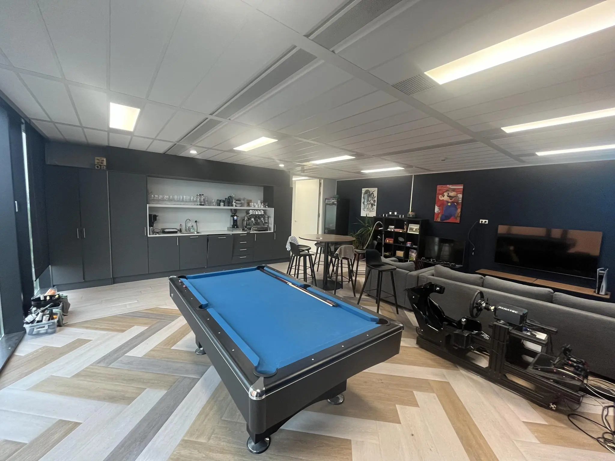 Moderne ontspanningsruimte aan de Winthontlaan met een pooltafel, gamestoelen, zithoek, groot tv-scherm en minibar.