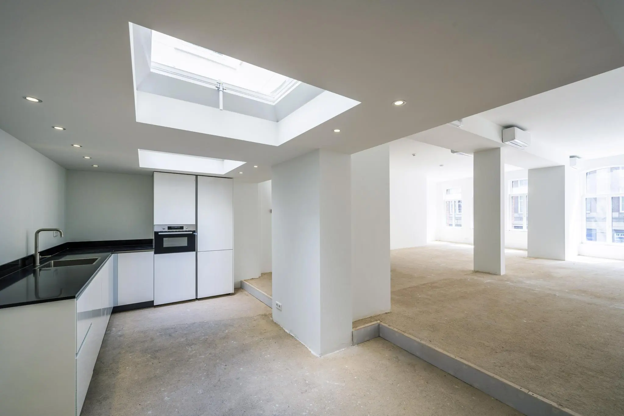 Lichte, ruime verdieping aan het Damrak met een moderne open keuken en grote raampartijen.