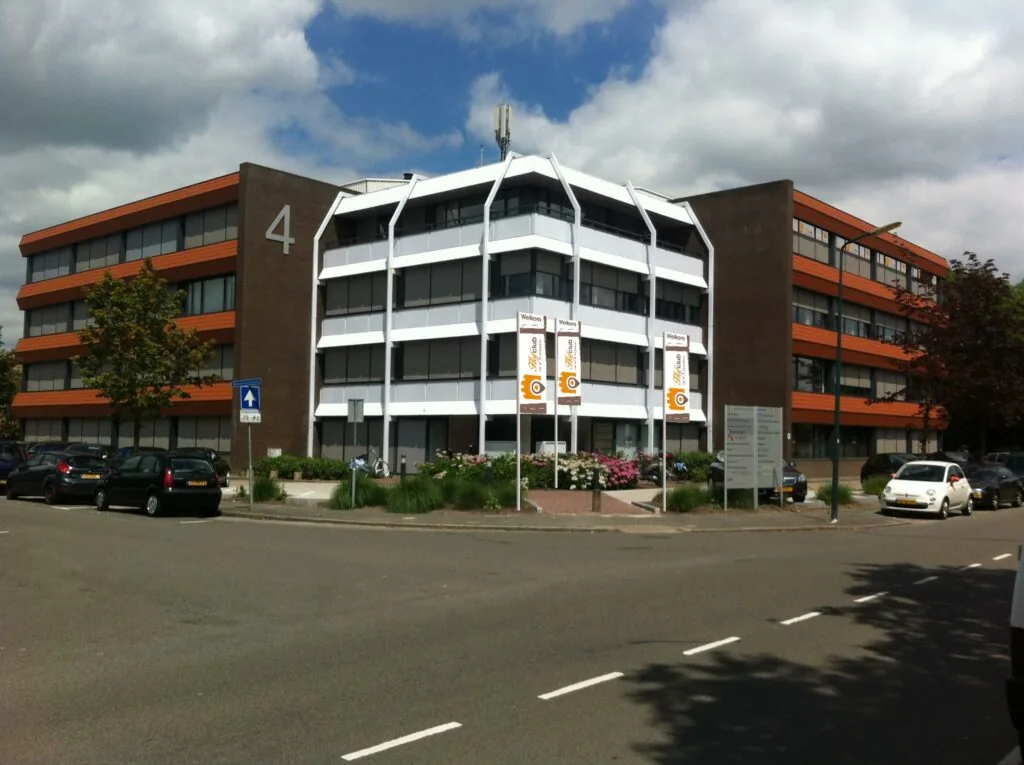 Kantoorgebouw aan de Zaagmolenlaan met nummer 4 en vlaggen bij de ingang.