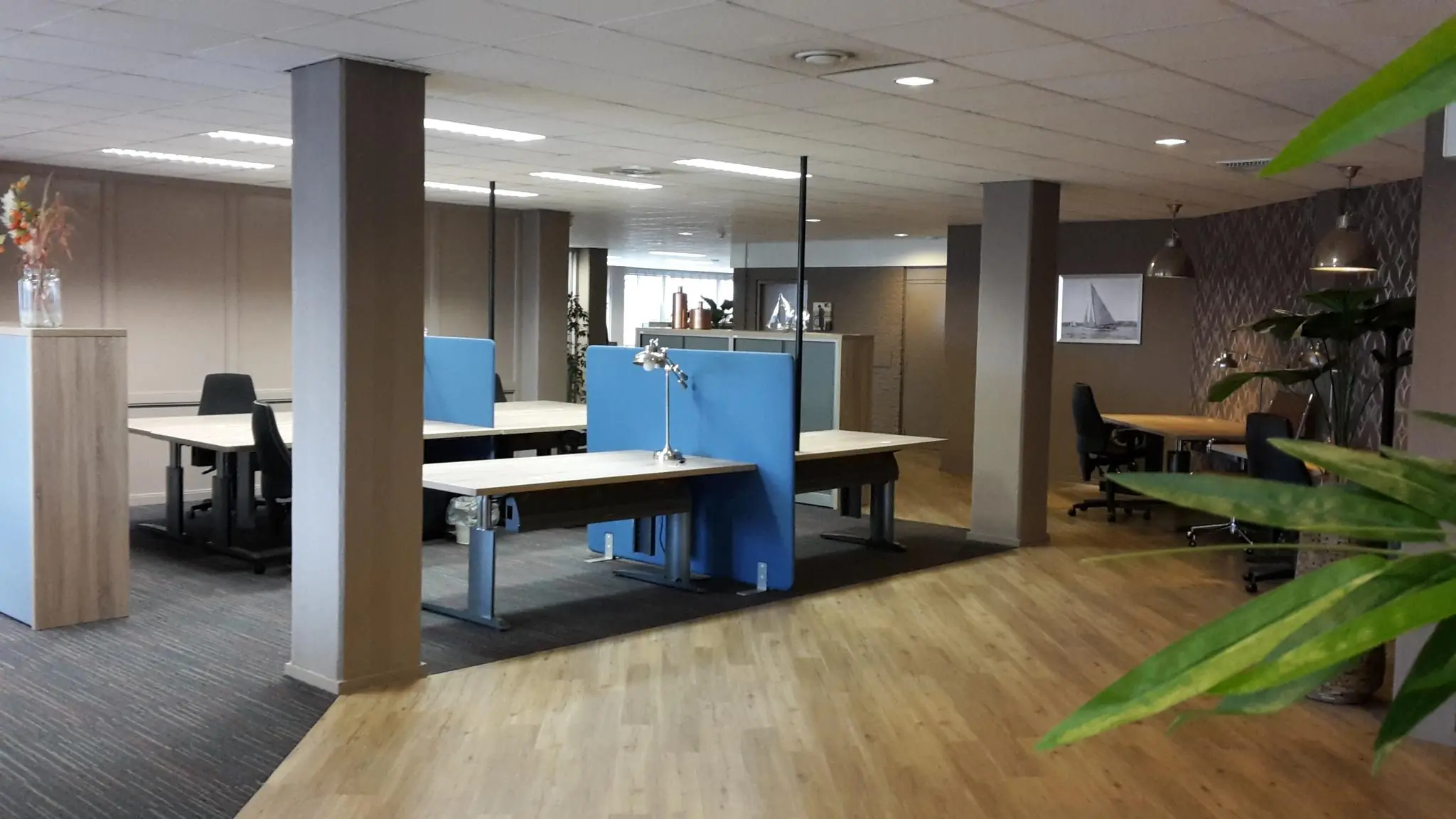 Moderne open kantoorruimte aan de Zaagmolenlaan met werkplekken, scheidingswanden en houten vloer.