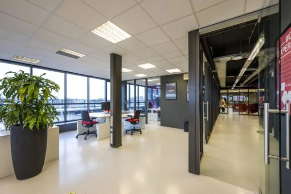 Modern ingerichte kantoorruimte aan de Anthony Fokkerweg met grote ramen, bureaus en een glazen gang.