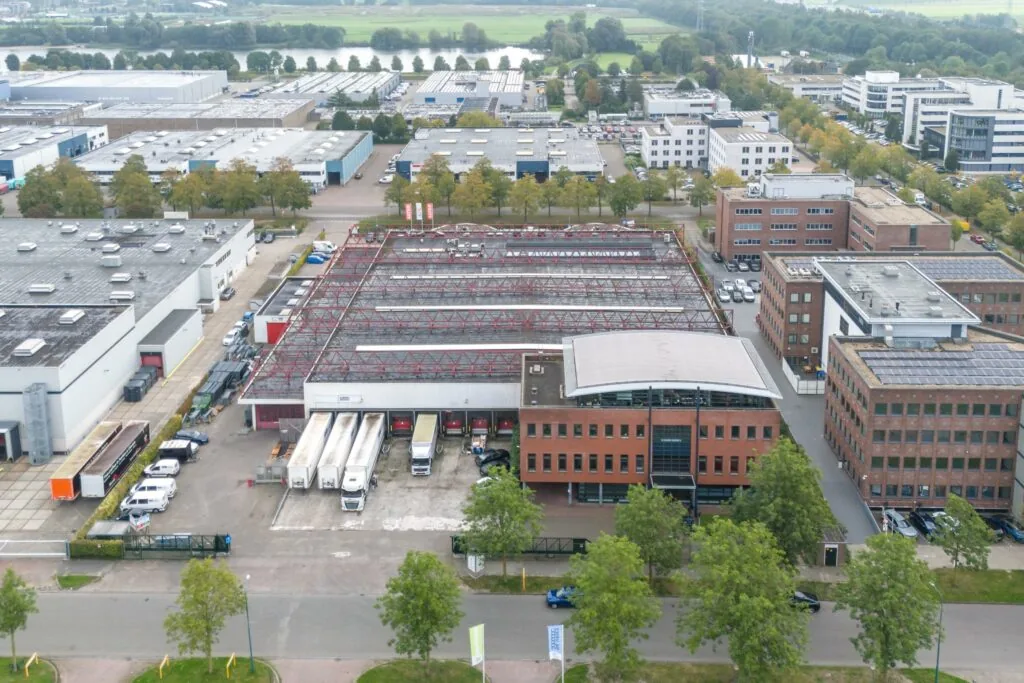 Luchtfoto van bedrijventerrein Veldzigt met kantoren, loodsen en vrachtwagens.