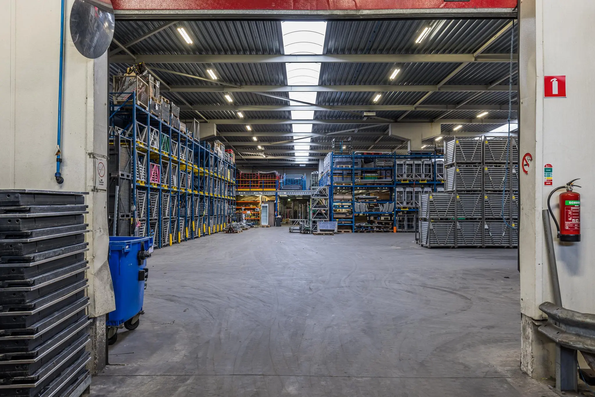 Ruim en gestructureerd magazijn met hoge stellages en metalen opslagrekken bij Veldzigt.