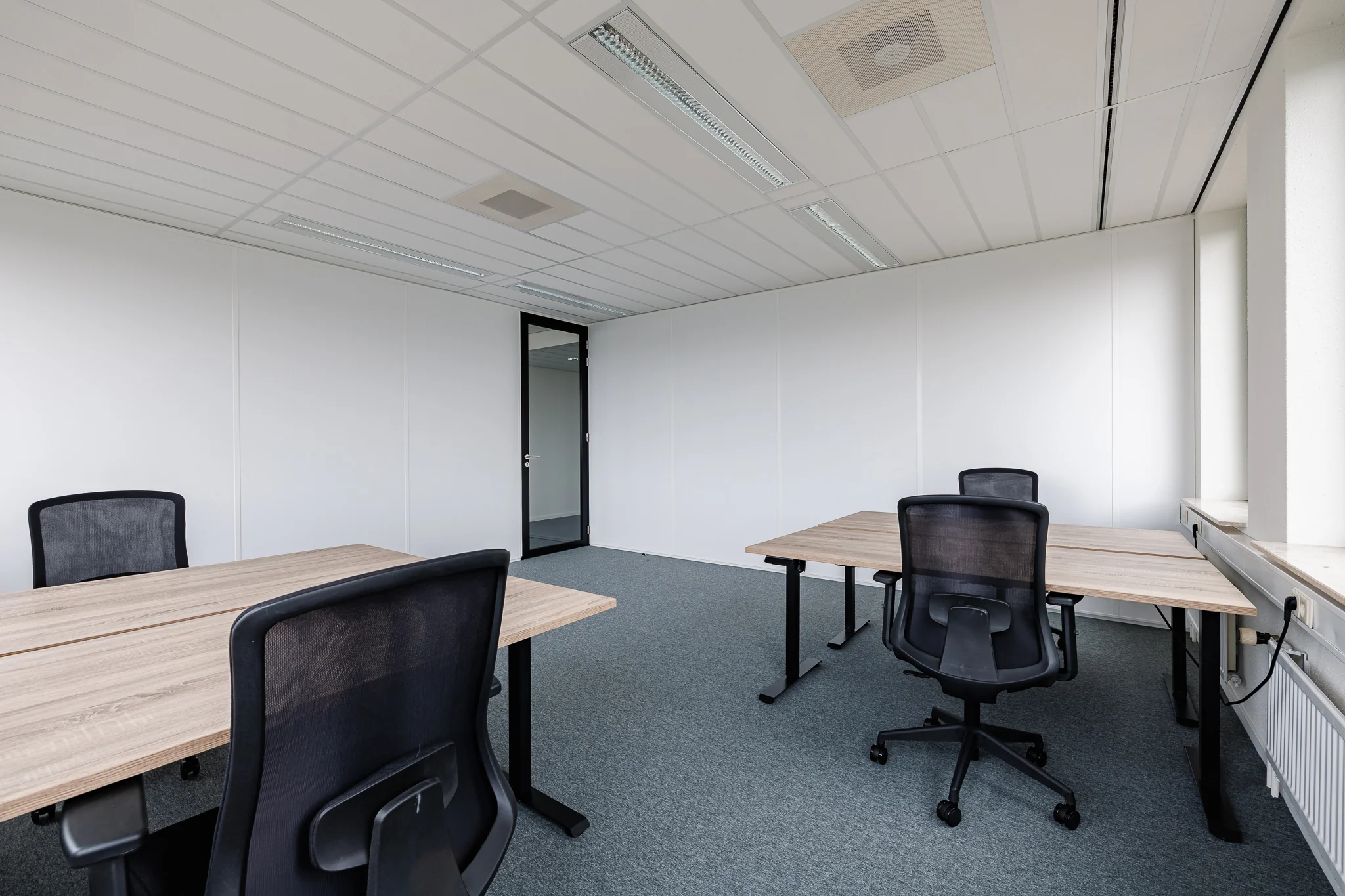 Een moderne, lege kantoorruimte met vier bureaus en stoelen bij Stadsring 201 in Amersfoort.