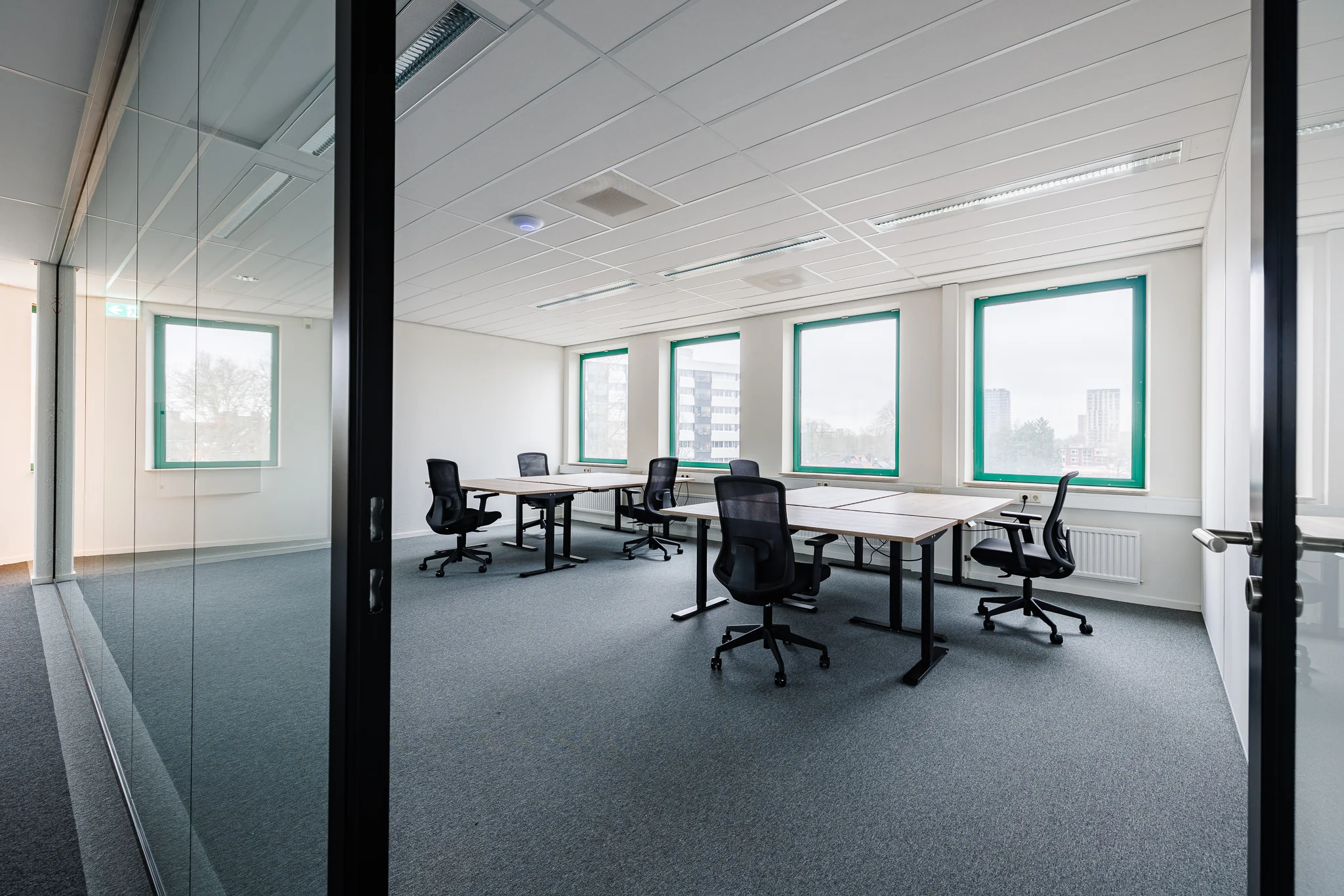 Een moderne en lege kantoorruimte met bureaus en bureaustoelen in Amersfoort.