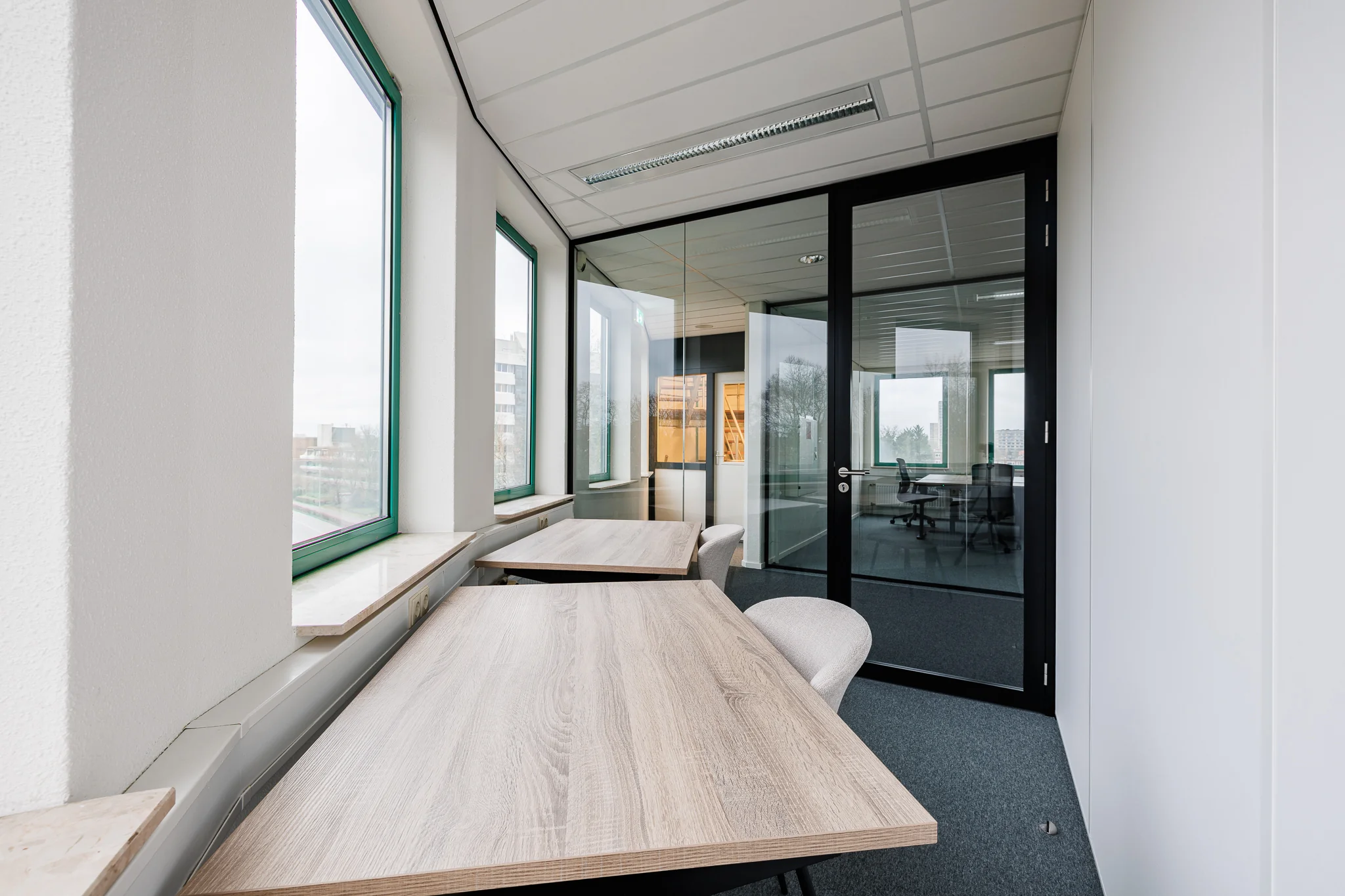 Een modern kantoor met houten bureaus en grote ramen, gelegen in Stadsring 201, Amersfoort.