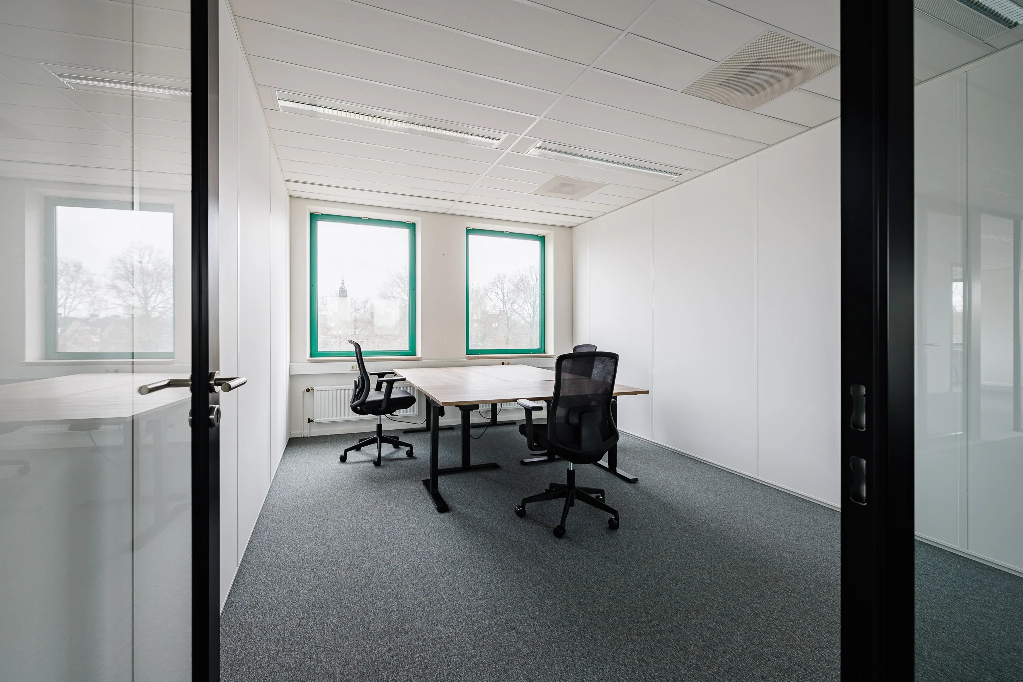 Een moderne, lege kantoorruimte met bureaus en stoelen bij de Stadsring 201 in Amersfoort.