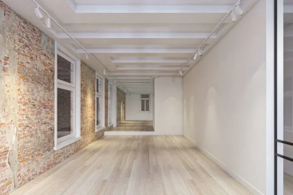 Licht en modern interieur van een ruimte aan het Rokin met houten vloer, bakstenen muur en grote ramen.