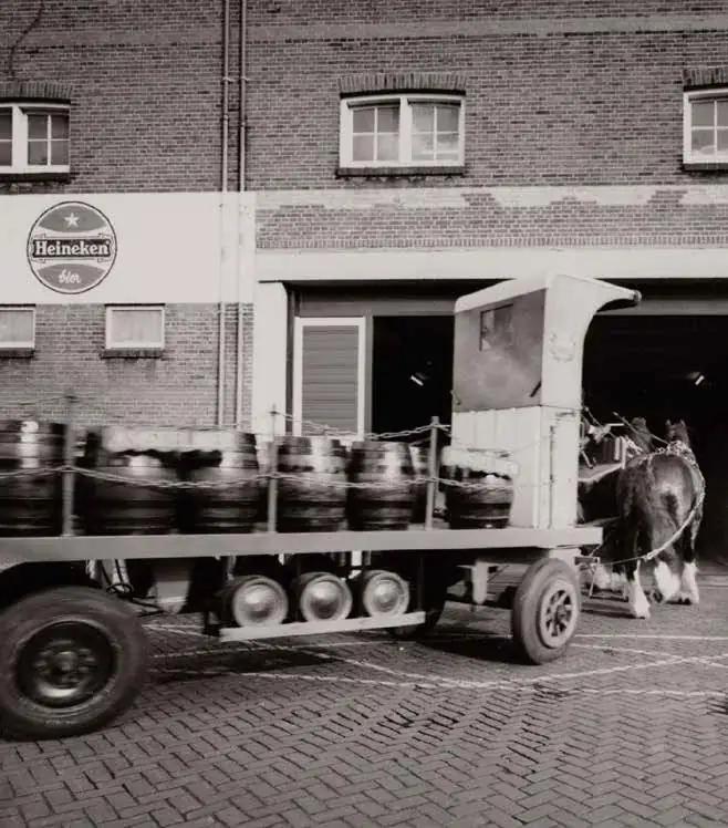 Paard en wagen met biervaten voor de Heineken brouwerij aan de Ruysdaelkade.
