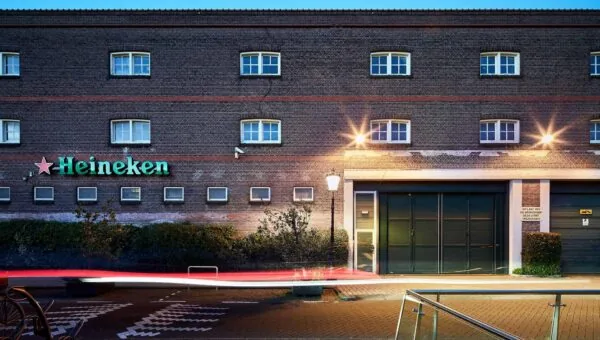 Vooraanzicht van het Heineken-gebouw aan de Ruysdaelkade in Amsterdam bij schemering.