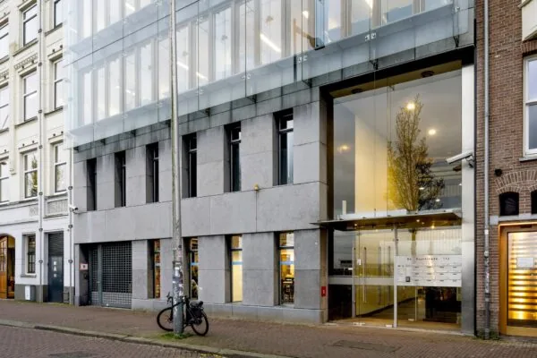 Modern kantoorgebouw met glazen entree aan de De Ruijterkade 112 in Amsterdam.