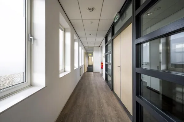 Licht en modern kantoorpand interieur met glazen wanden en houten vloer aan de Paasheuvelweg.