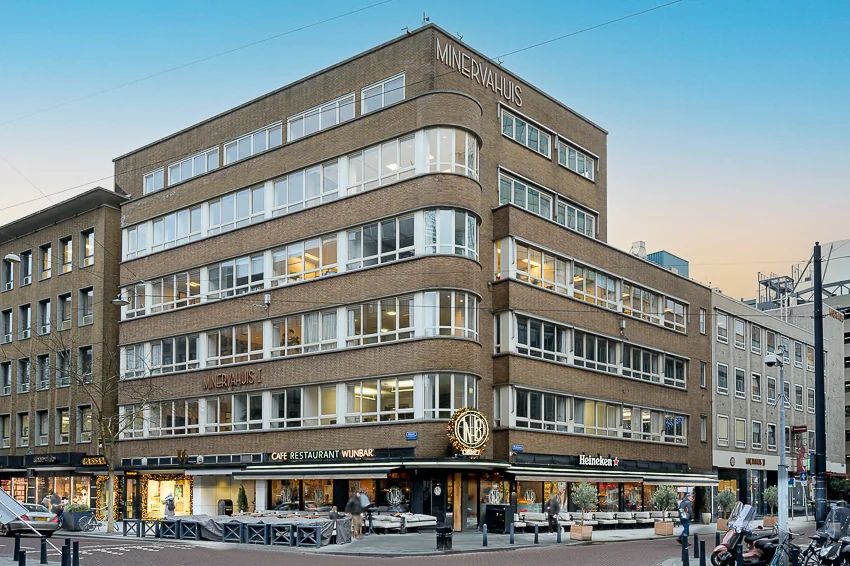 Hoekpand Minervahuis aan de Meent in Rotterdam met cafés en winkels op de begane grond.