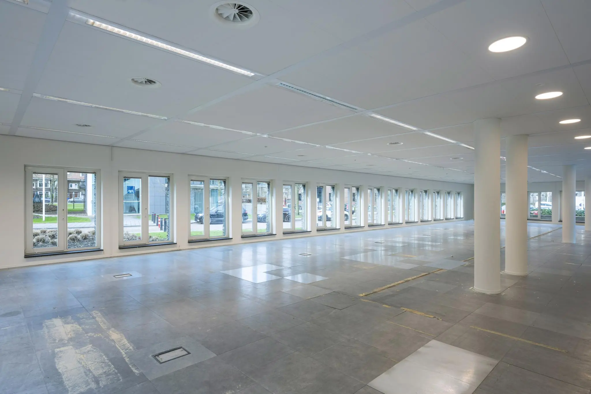 Leeg kantoorpand aan de De Cuserstraat met veel ramen en systeemplafond.