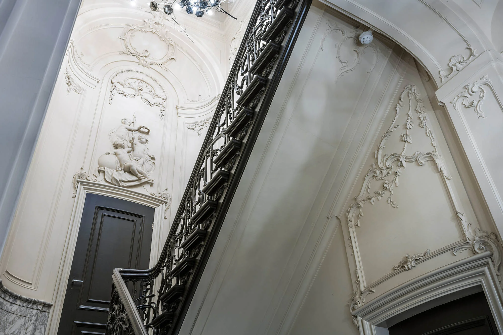 Sierlijke trap met rijk gedecoreerde stucreliëfs en klassieke beeldhouwwerken in een monumentaal pand aan de Herengracht.