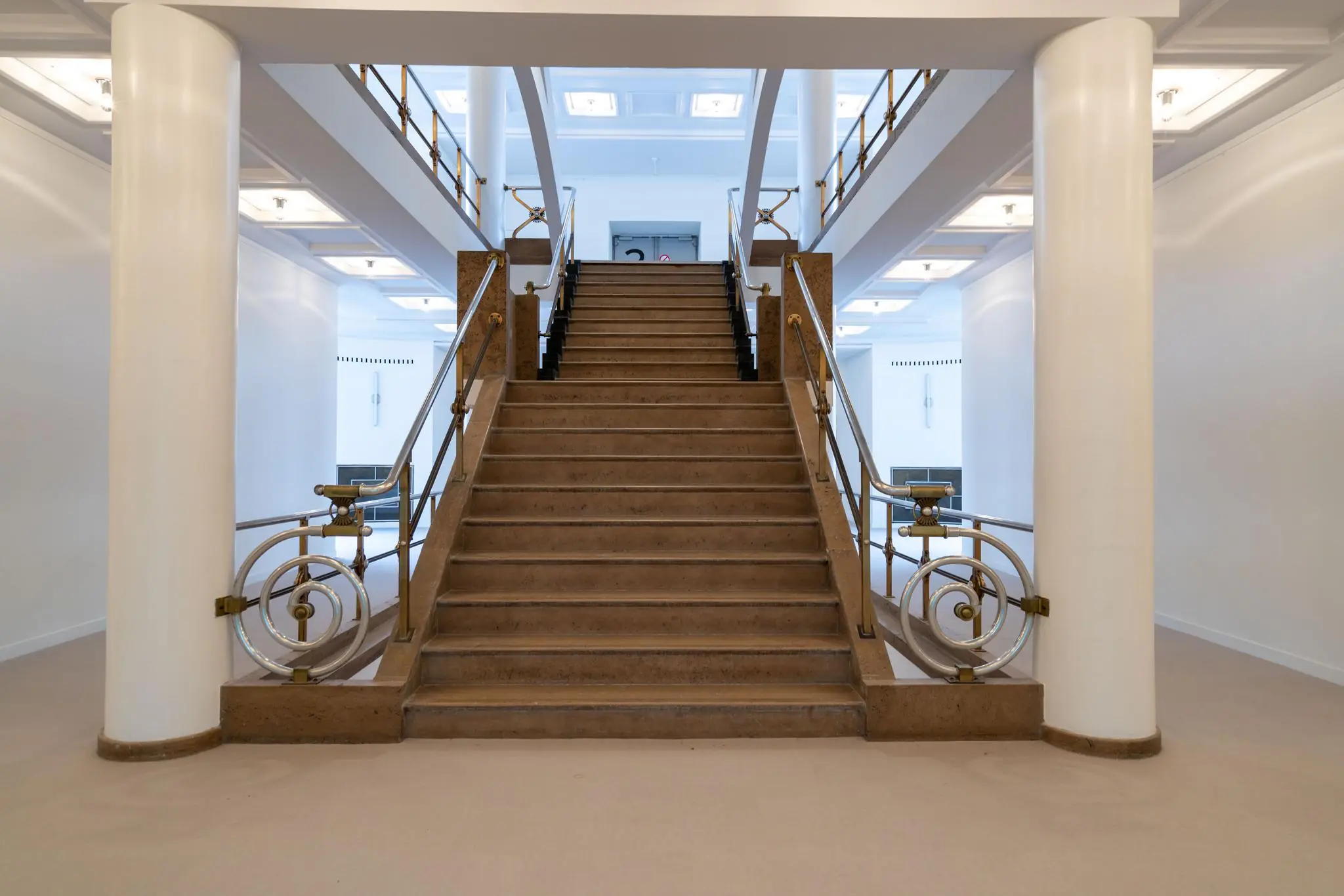 Symmetrisch trappenhuis met art-deco elementen in een licht en modern interieur aan de Wassenaarseweg.