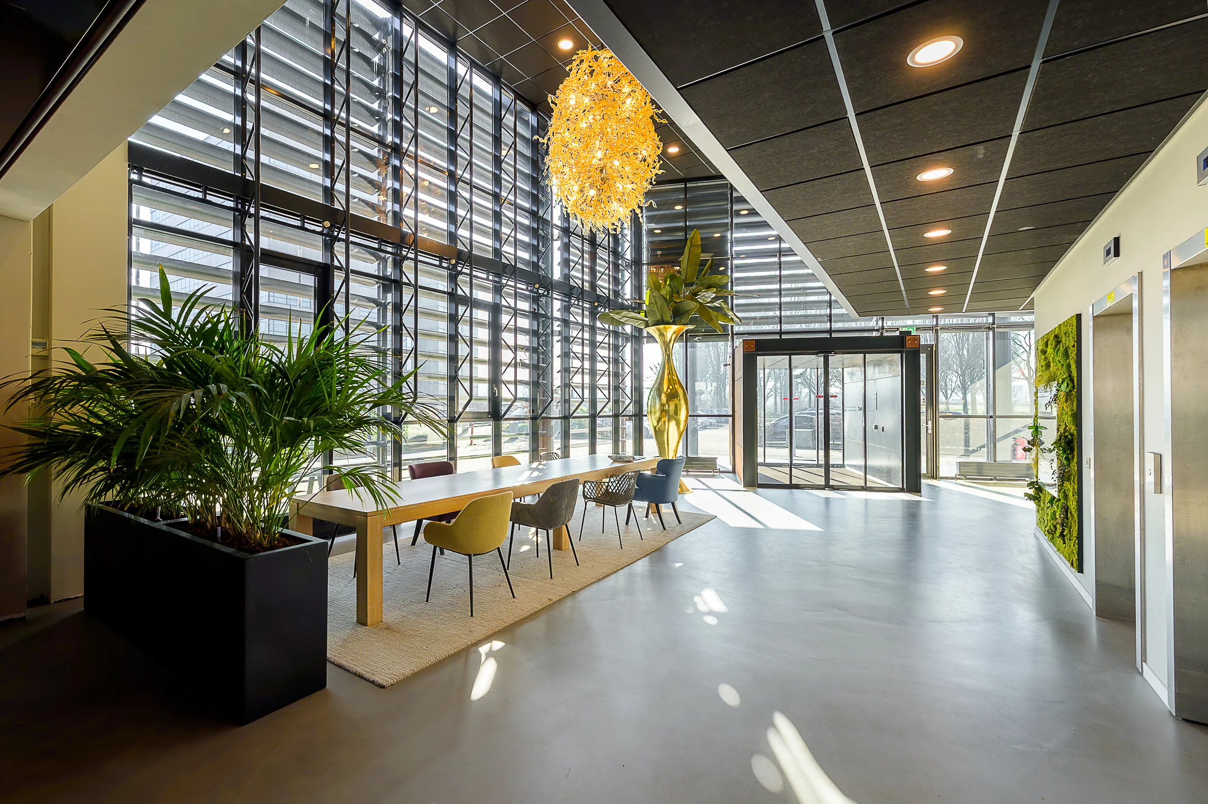 Modern office lobby at Rivium Quadrant with large windows, colorful chairs, and indoor plants.