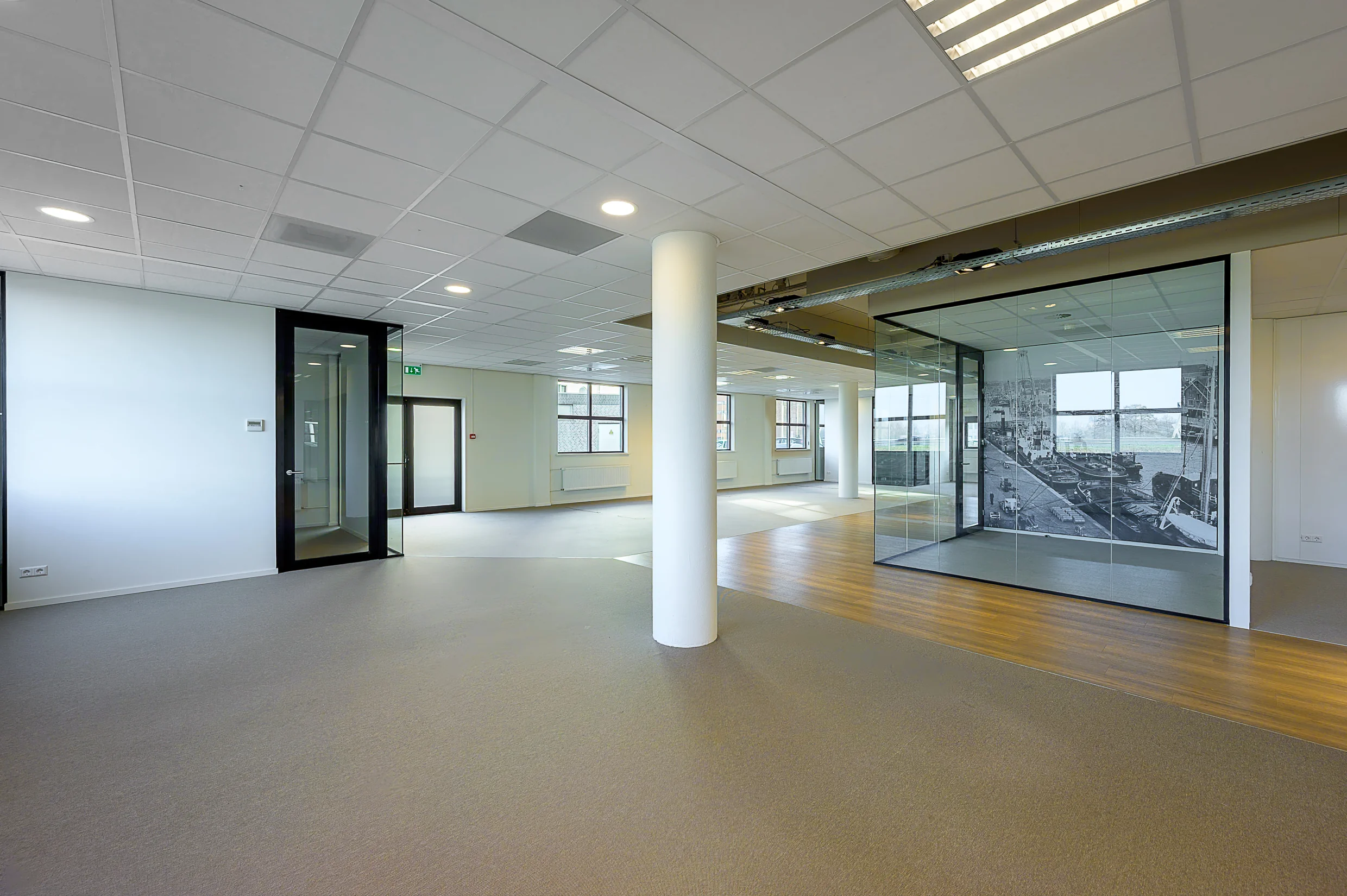 Modern office space at Rivium Quadrant with glass-walled meeting room and large windows.