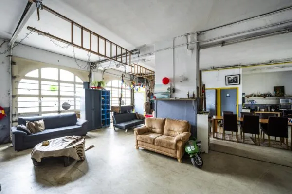 Ruime en creatieve woonruimte aan de Baarsjesweg met zitgedeelte, eethoek en industriële details.