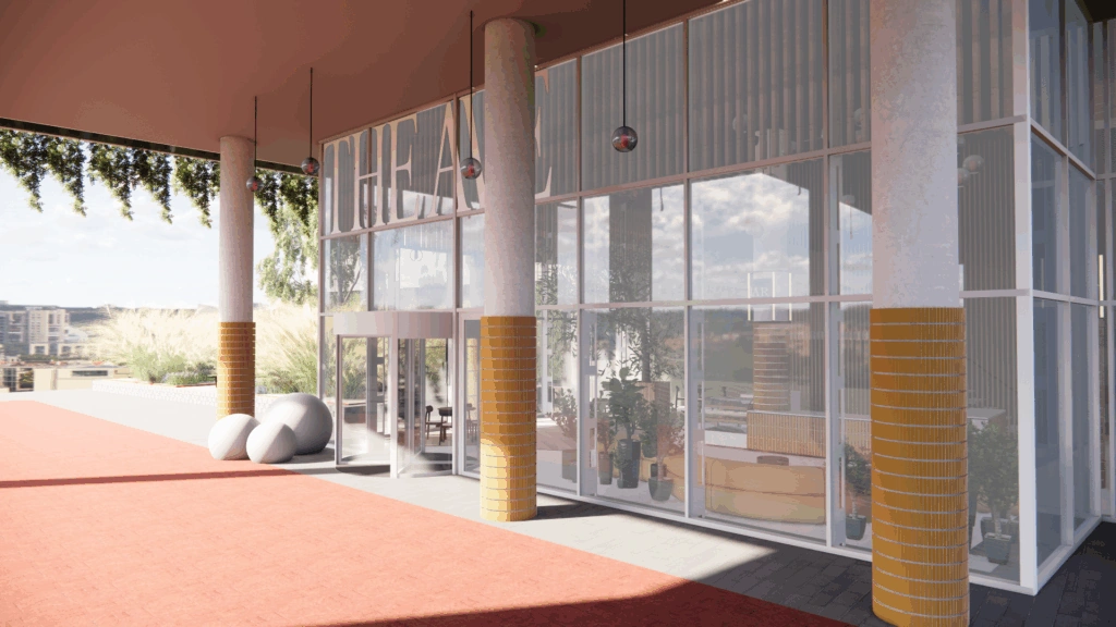 Moderne glazen entree van het Scorpius Theater met hoge zuilen en planten binnenin.