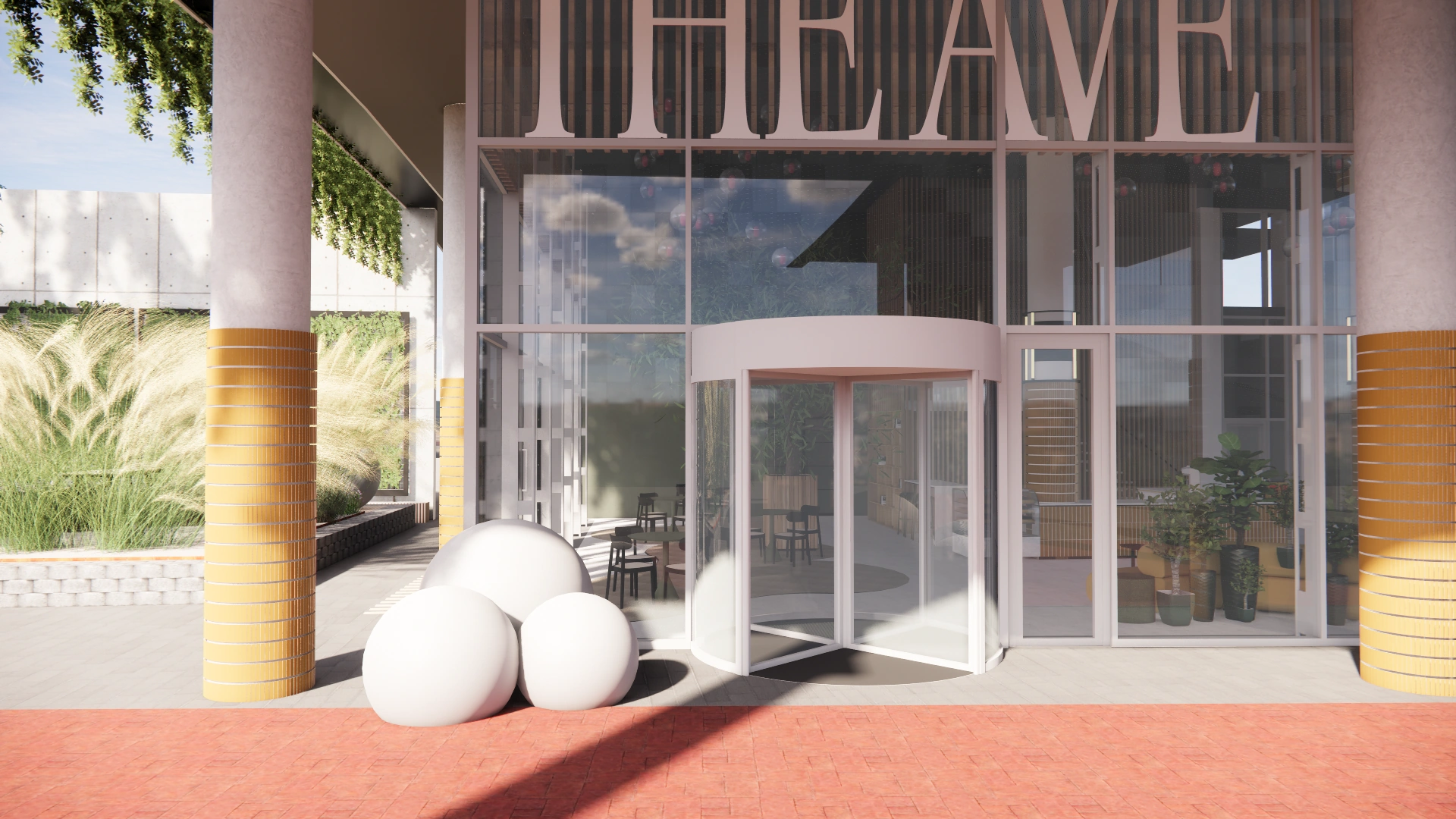 De ingang van gebouw The Avenue met een glazen draaideur, grote ronde decoratieve objecten en gele zuilen.