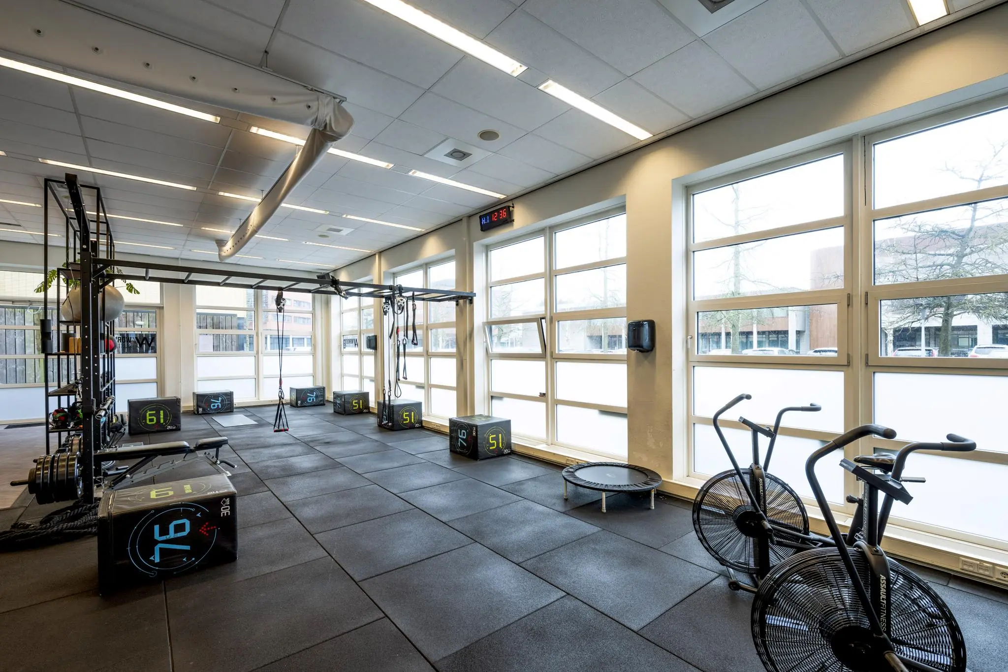 Moderne fitnessruimte aan de H.J.E. Wenckebachweg met fitnessapparatuur, plyoboxen en grote raampartijen.