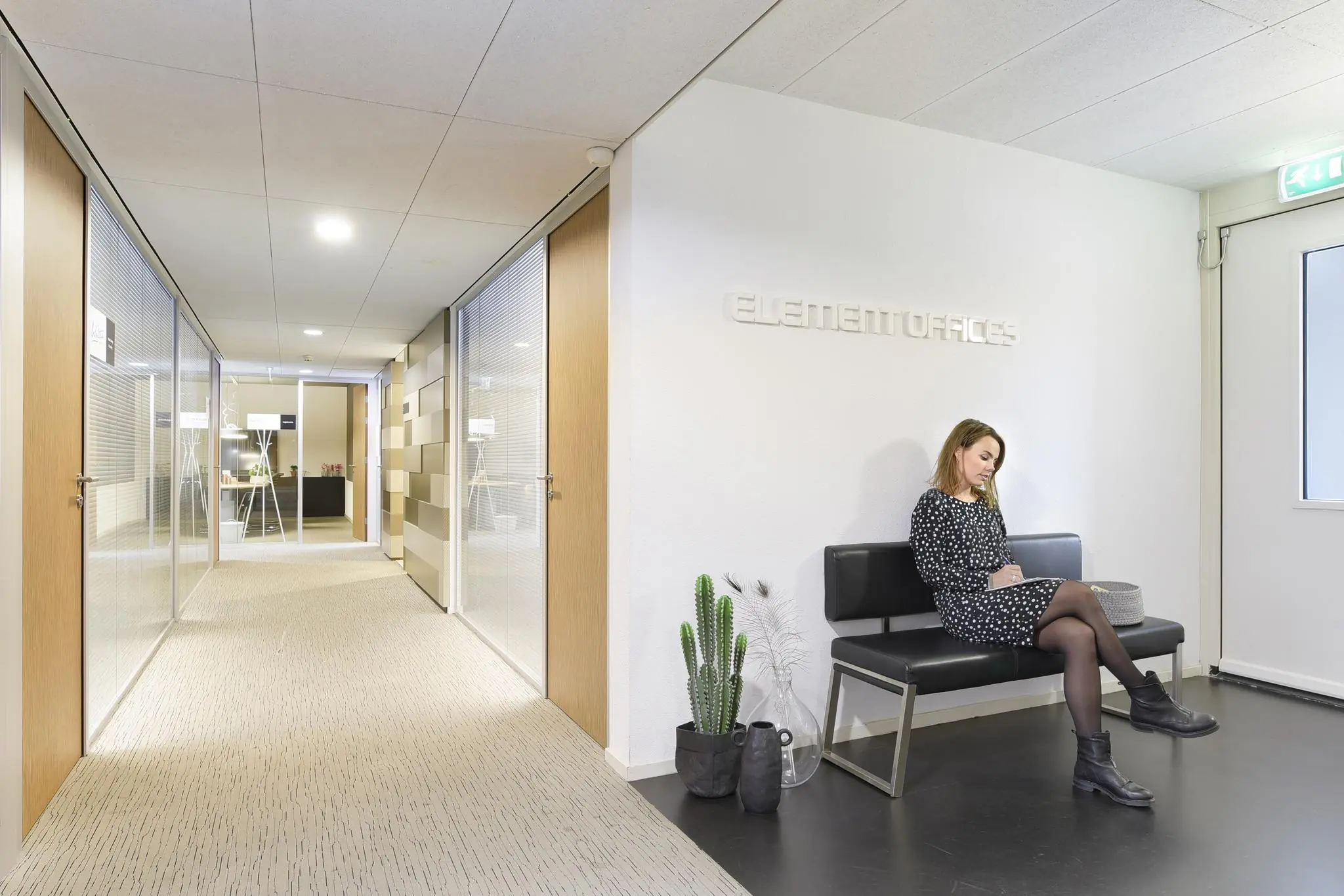Vrouw zit te wachten in de wachtruimte van Element Offices in de Middenburcht.