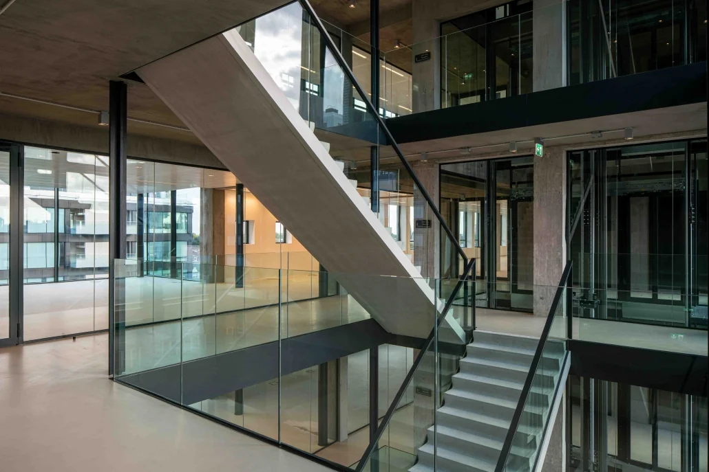 Moderne betonnen trap met glazen balustrades in kantoorgebouw aan de Catharijnesingel.