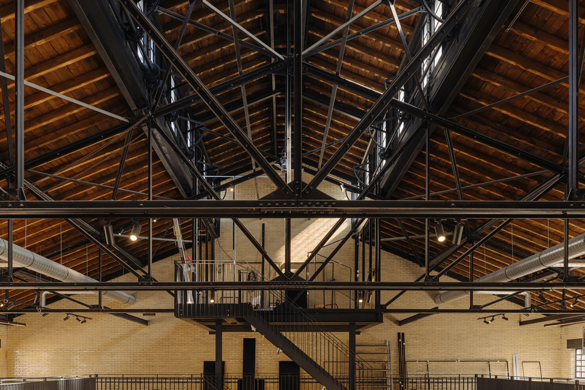 Industrieel interieur van een gerenoveerd gebouw aan de Leidseweg met zicht op het houten dak en stalen spanten.