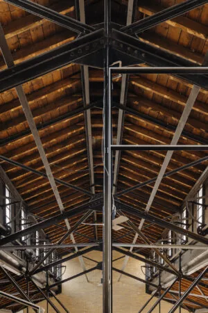 Interieur van een industrieel gebouw aan de Leidseweg met een houten dakconstructie en stalen spanten.