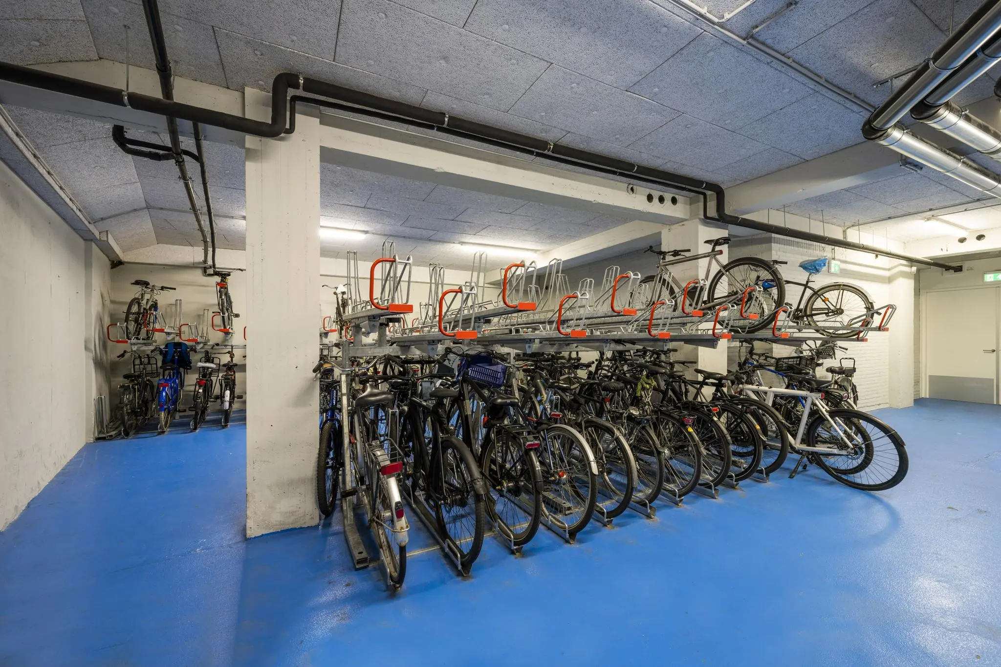 Fietsenstalling met dubbele rekken in een moderne, blauwe kelderruimte aan de Singel.