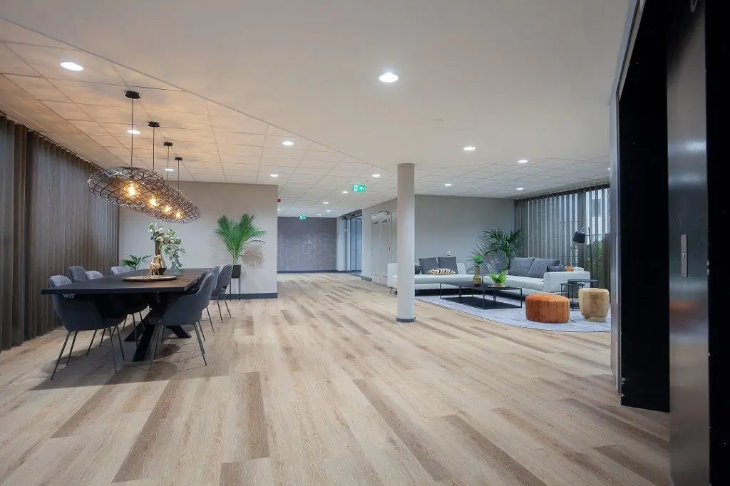 Moderne, ruim opgezette lounge- en vergaderruimte aan de Cypresbaan met strakke inrichting, houten vloer en stijlvolle verlichting.