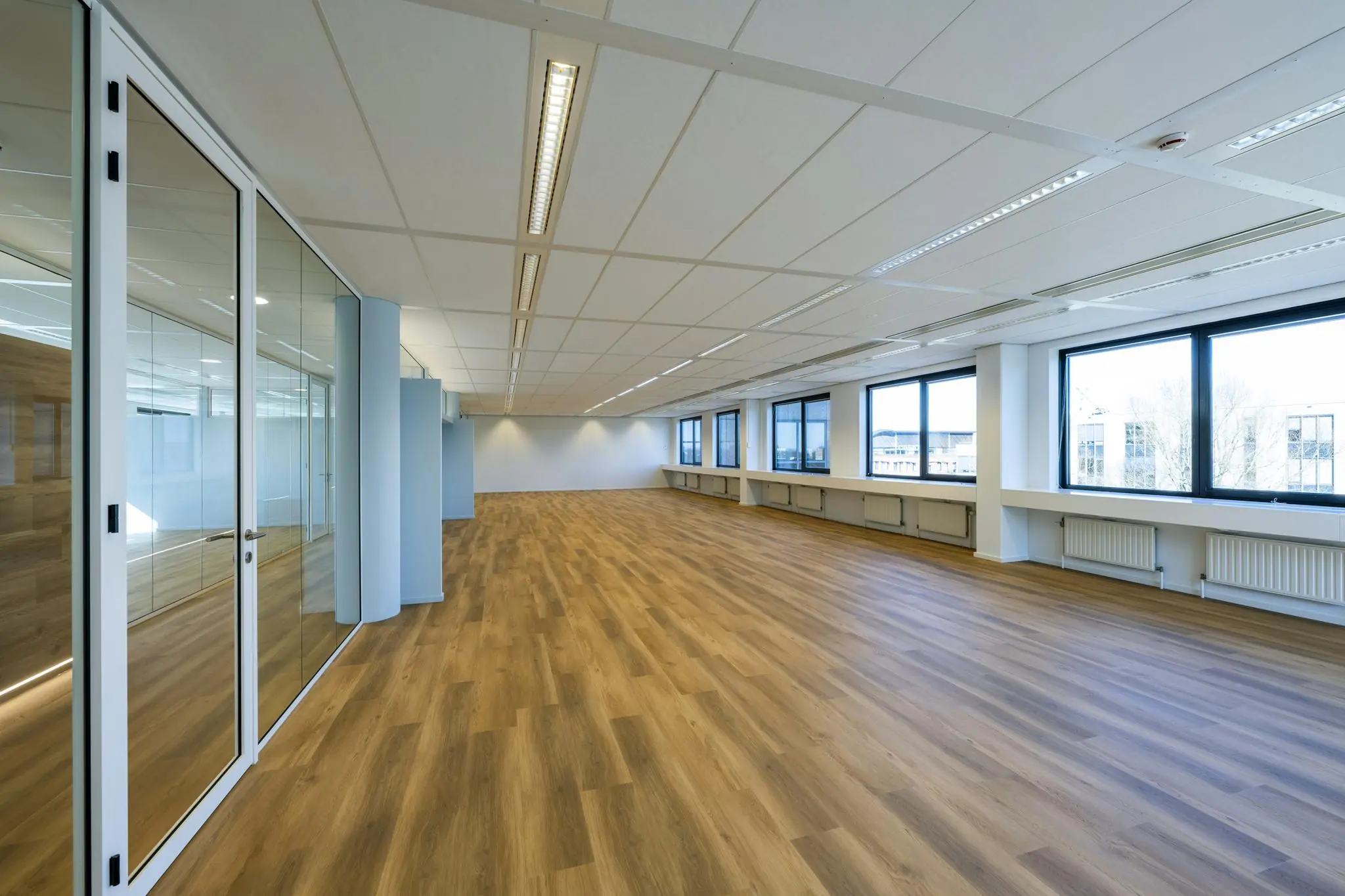 Lichte, moderne kantooretage met houten vloer en grote ramen aan de Prof. W.H. Keesomlaan.