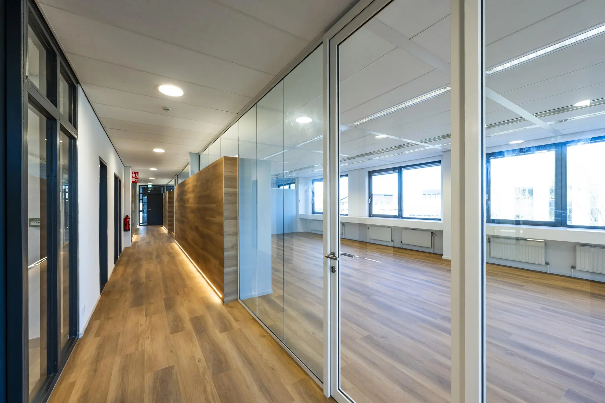 Moderne kantoorruimte aan de Prof. W.H. Keesomlaan met glazen wanden, houten vloeren en veel daglicht.
