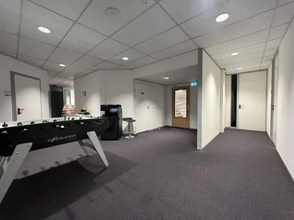 Kantoorhal met een tafelvoetbaltafel, printer en een deur met het logo van "The Inside Office" op Industrieweg.