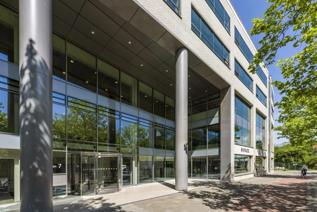 Moderne kantoorgebouw aan de Mr. Treublaan met grote glazen gevel en ingang van SPACES.