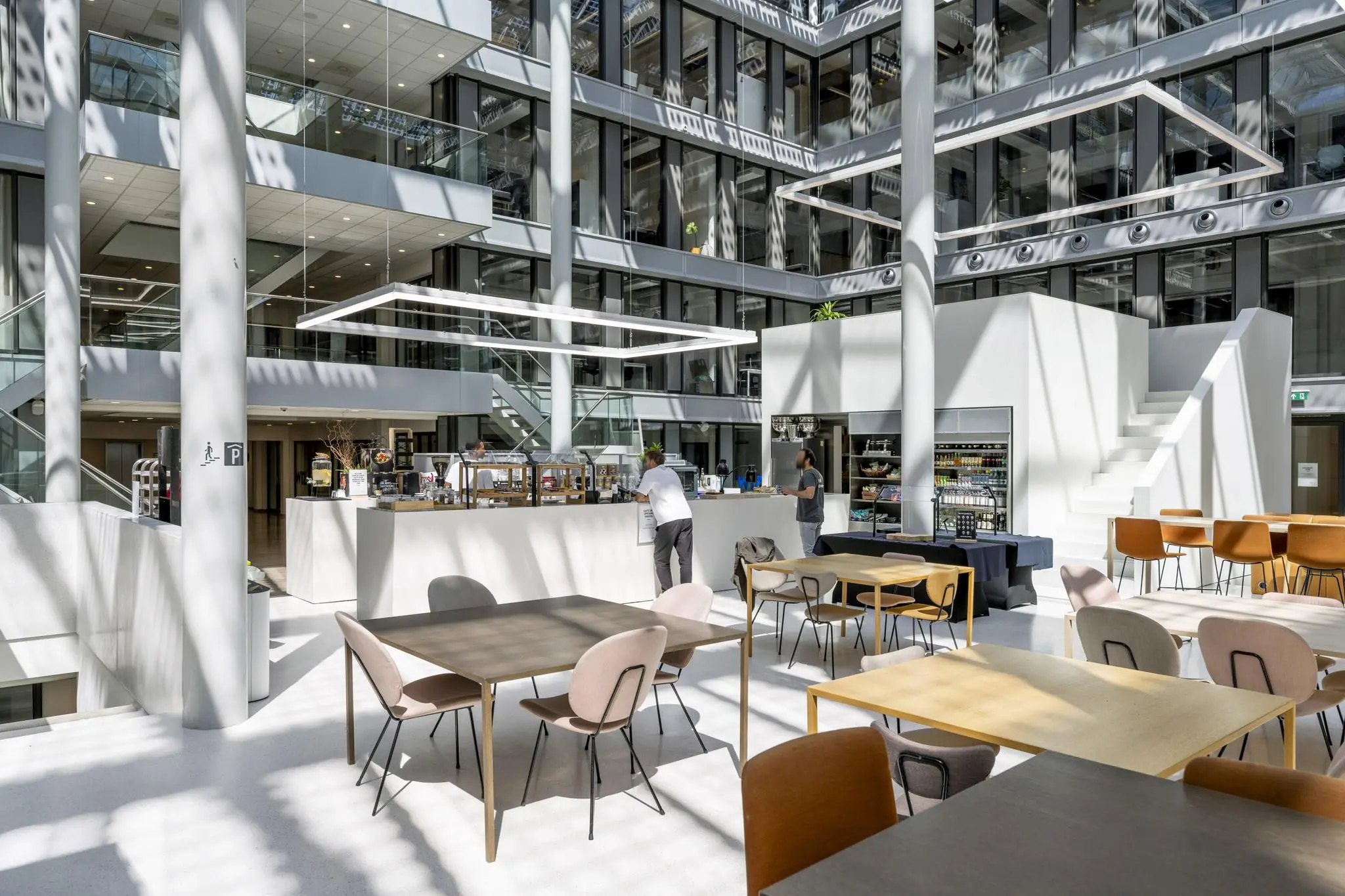 Moderne en lichte kantoorlobby aan de Mr. Treublaan met zitplaatsen, een koffiebar en een zelfbedieningswinkel.