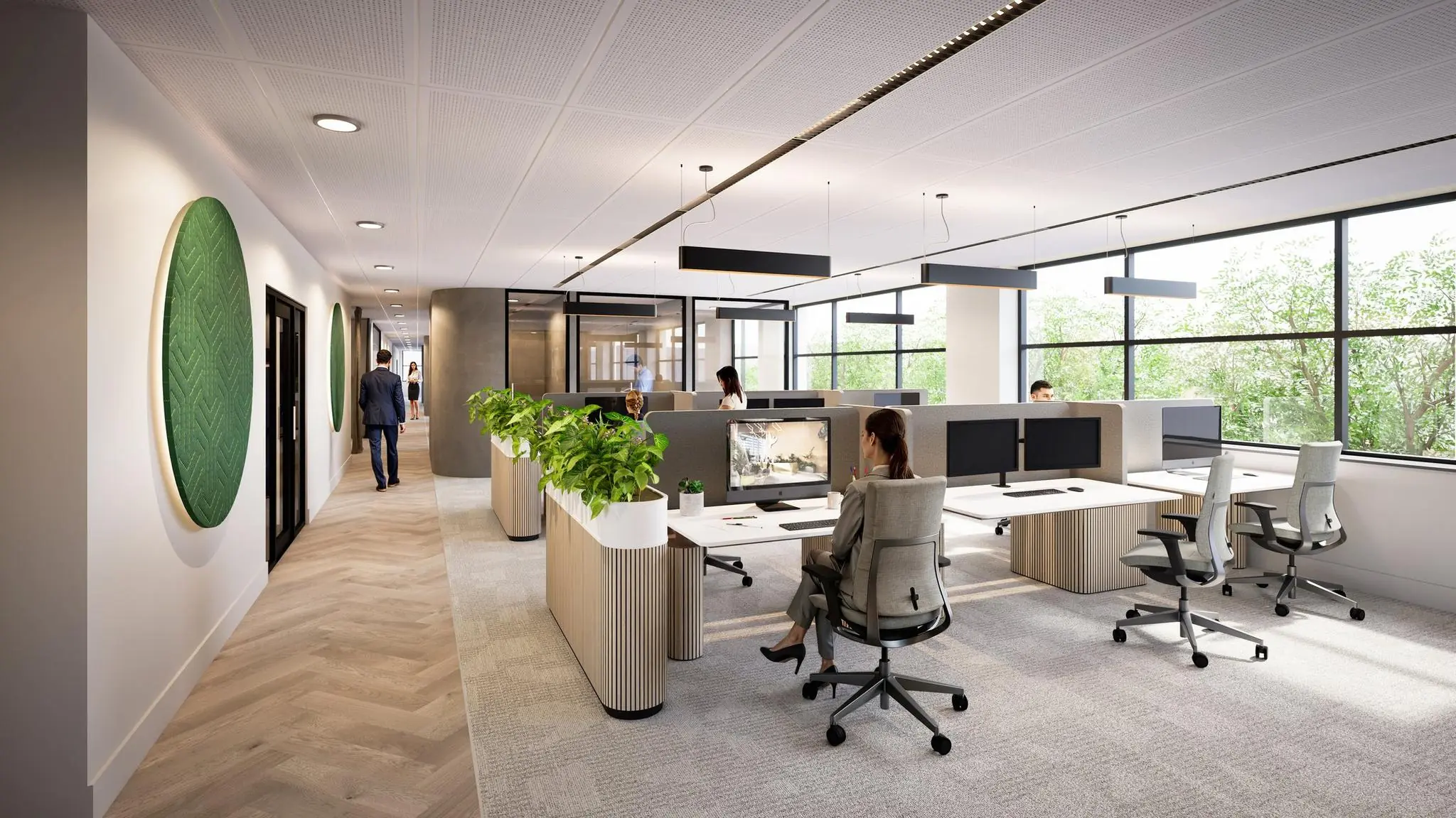 Moderne kantoortuin in De Entree met werkplekken, planten en grote ramen met uitzicht op groen.