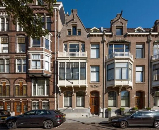 Voorgevel van een klassiek herenhuis aan de Paulus Potterstraat in Amsterdam, met sierlijke erkers en witgeschilderde balkonnetjes.