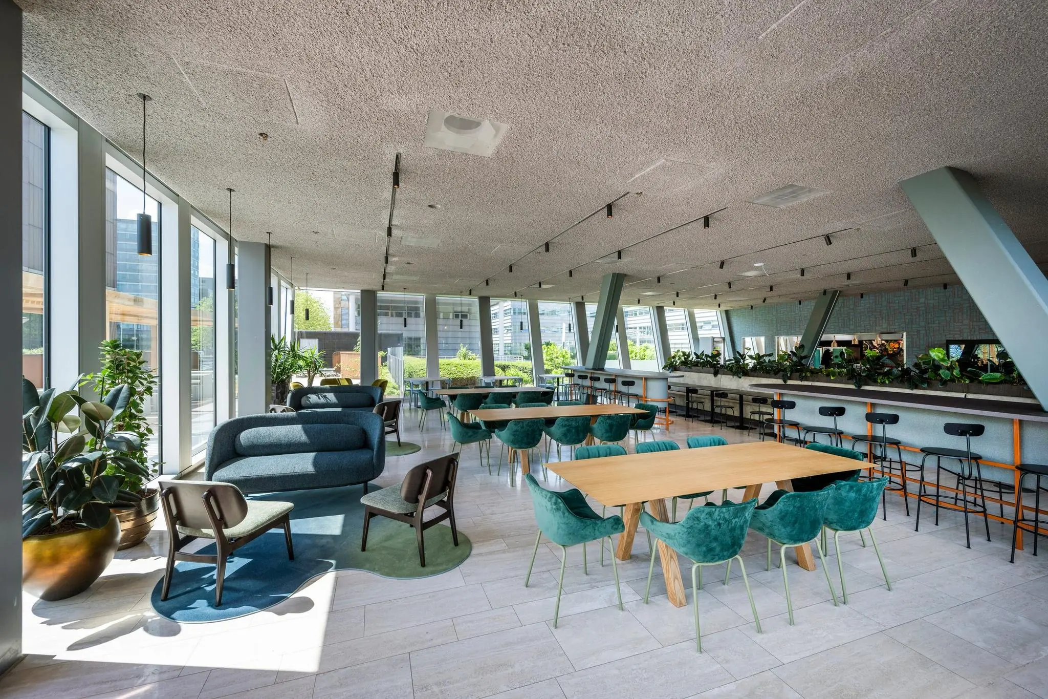 Modern ingerichte lounge- en werkruimte aan de David Ricardostraat met veel daglicht, planten en zitgelegenheden.