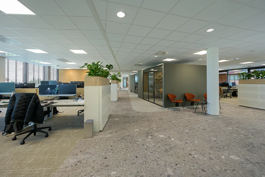 Modern open-plan office interior on Laan van Barcelona with workstations, meeting rooms, and seating area.