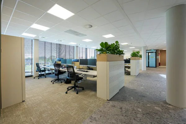 Modern open-plan office space on Laan van Barcelona with desks, ergonomic chairs, and indoor plants.