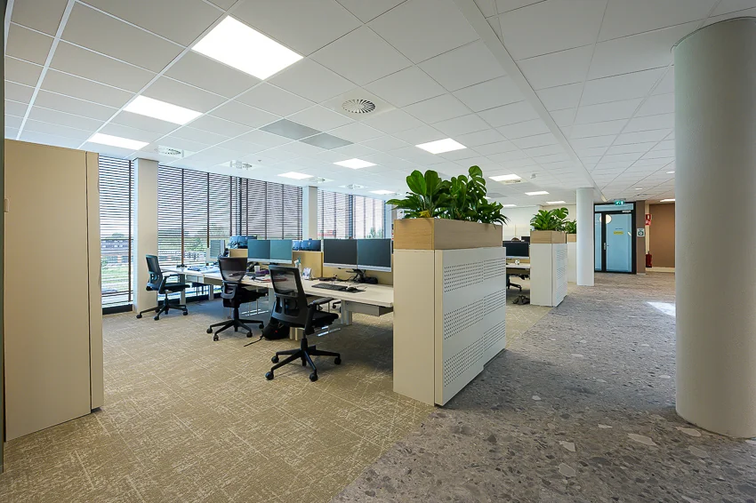 Modern open-plan office space on Laan van Barcelona with desks, ergonomic chairs, and indoor plants.