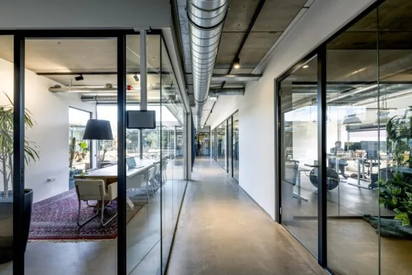 Moderne kantoorruimte aan de Johan van Hasseltweg met glazen vergaderruimtes en industriële plafonddetails.