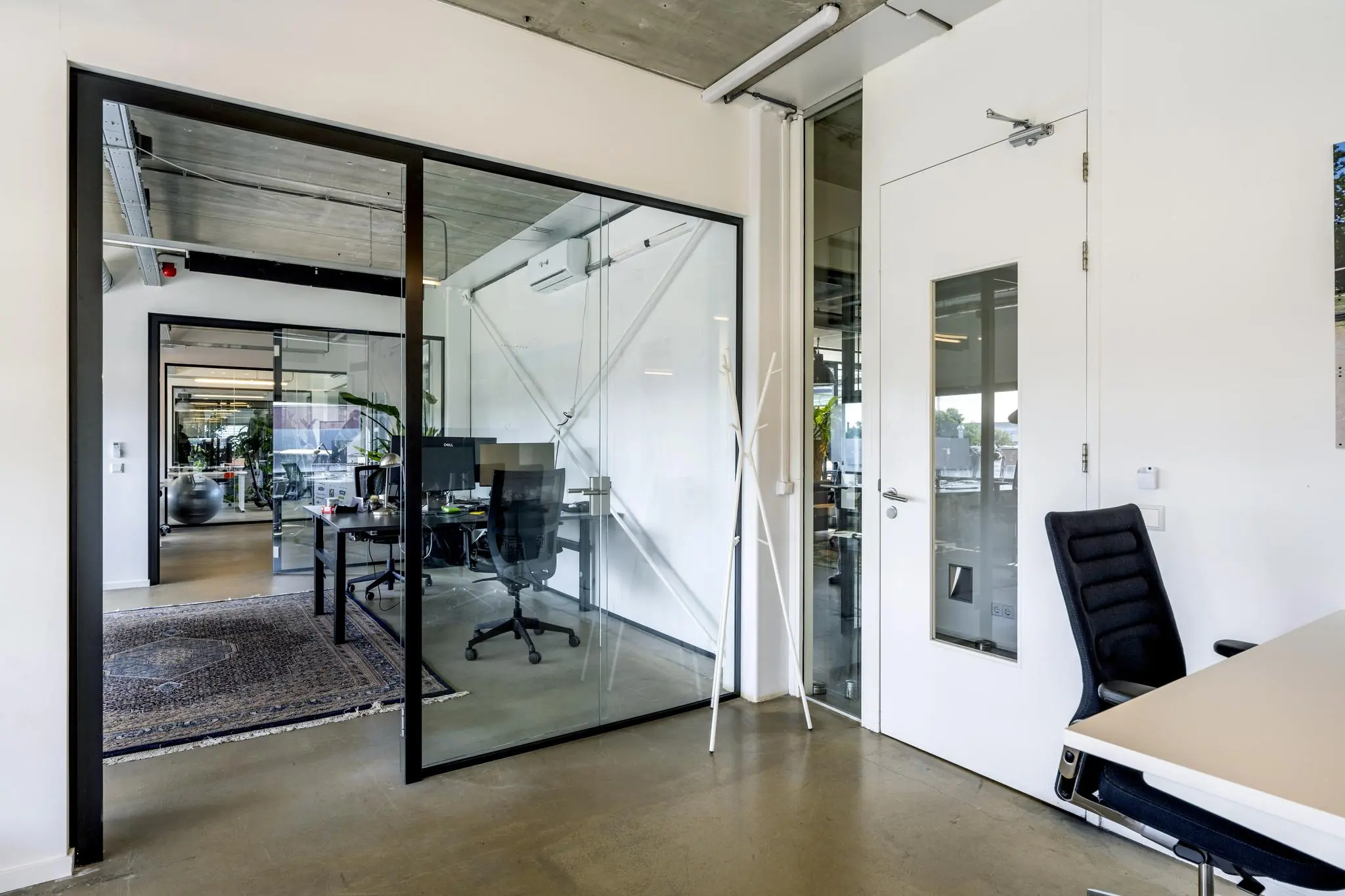Moderne kantoorruimte aan de Johan van Hasseltweg met glazen wanden, bureaus en ergonomische stoelen.