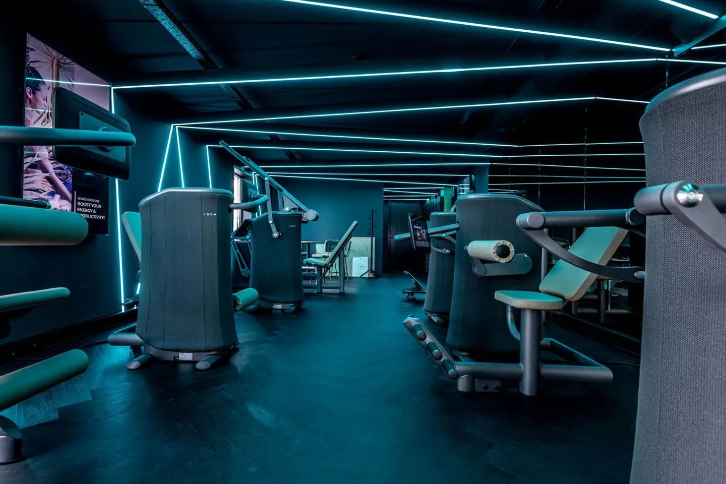 Moderne fitnessruimte aan de Plaatweg met verschillende krachttrainingsapparaten en blauwe ledverlichting.