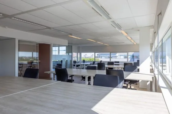 Licht en modern kantoorinterieur aan de Overschiestraat met meerdere bureaus en bureaustoelen.